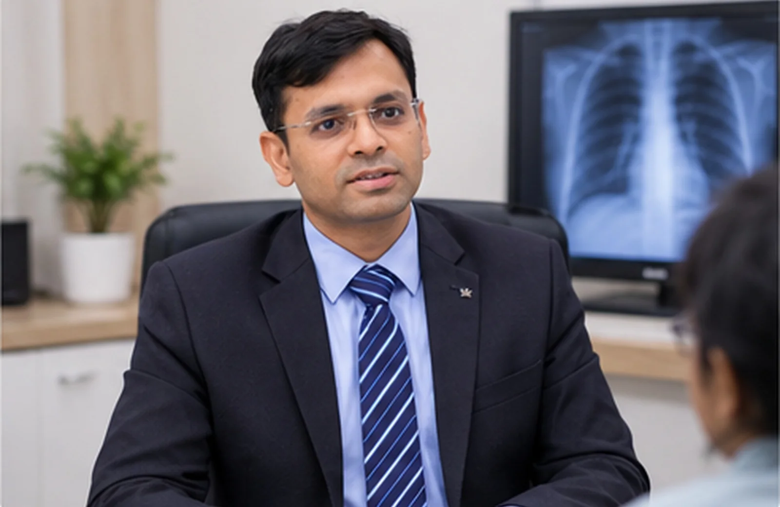 Dr. Arun Gangadhar reviewing a chest X-ray with a patient